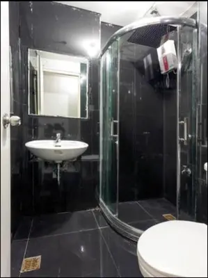 a bathroom with a glass shower and a sink at Sm Mezza Residences in Manila