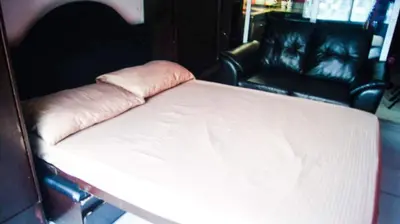 a white bed in a room with a couch at Sm Mezza Residences in Manila