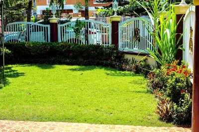 a yard with a white fence and some flowers at Entire House with 4 rooms near SM Molino and Vermosa Ayala in Imus