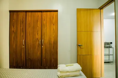 a bedroom with a bed and a wooden cabinet at Salem's Abode in Manila