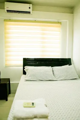 a bedroom with a large white bed with a window at Salem's Abode in Manila