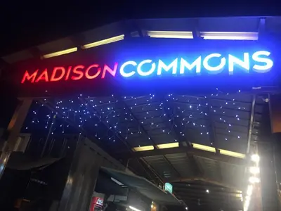 a neon sign for madison commissaries on a building at Food District Hostel - Ortigas Kapitolyo in Manila