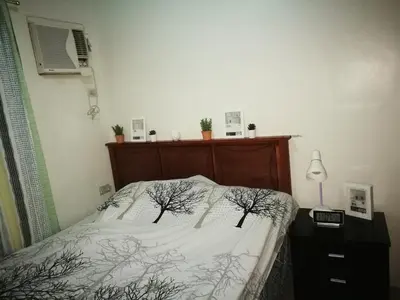 a bedroom with a bed with trees on it at 2 BR Sorrento Oasis in Manila