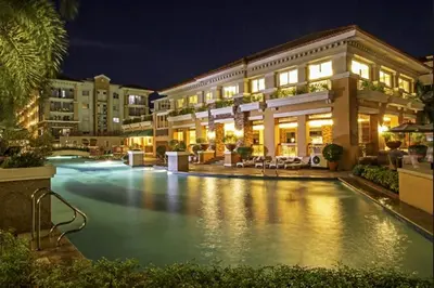 a swimming pool in front of a building at night at 2 BR Sorrento Oasis in Manila