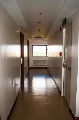 an empty hallway with a window in a building at Titan Condo at Studio City Tower 1 Alabang in Manila