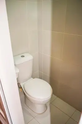 a bathroom with a white toilet in a room at Titan Condo at Studio City Tower 1 Alabang in Manila