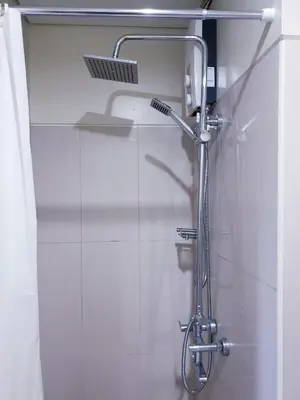 a shower with a shower head in a bathroom at The Palawanos Home at Shell Residences in Manila