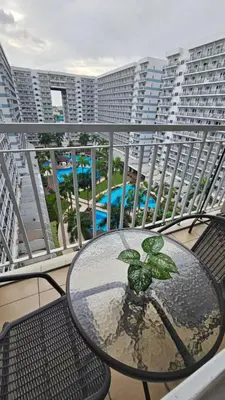 a table with a plant on a balcony with buildings at The Palawanos Home at Shell Residences in Manila