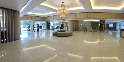 a lobby of a building with a chandelier at The Palawanos Home at Shell Residences in Manila
