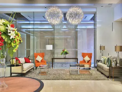 a living room with two couches and a chandelier at Valero Grand Suites by Swiss-Belhotel in Manila