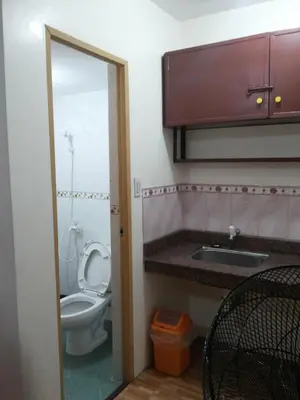 a bathroom with a toilet and a sink and a mirror at Budget Studio Unit in Makati in Manila