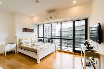 a bedroom with a bed and a large window at 1BR Milano Residences by Versace in Manila