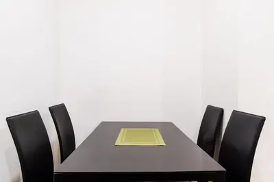 a table with chairs and a yellow book on it at 1BR Milano Residences by Versace in Manila