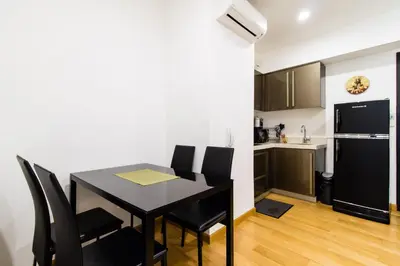 a kitchen and dining room with a black table and chairs at 1BR Milano Residences by Versace in Manila