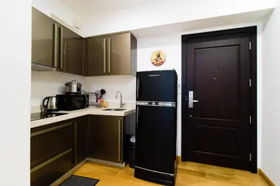 a kitchen with a black refrigerator next to a door at 1BR Milano Residences by Versace in Manila