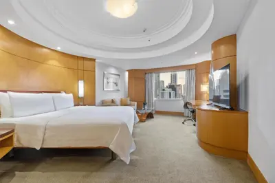 a hotel room with a large bed and a television at Makati Shangri-La, Manila in Manila