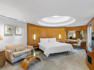 a bedroom with a bed and a couch and a desk at Makati Shangri-La, Manila in Manila
