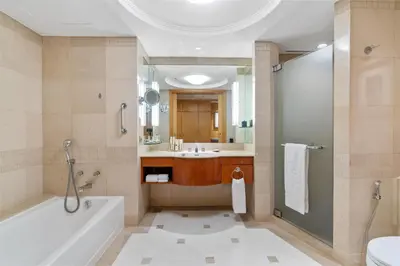 a bathroom with a tub and a shower and a sink at Makati Shangri-La, Manila in Manila