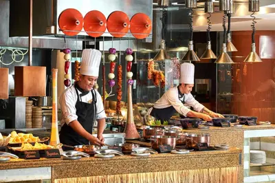 two chefs standing in a kitchen preparing food at Makati Shangri-La, Manila in Manila