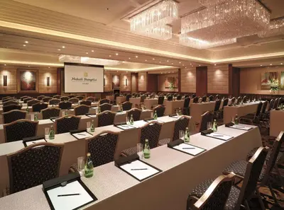 a conference room with tables and chairs and a screen at Makati Shangri-La, Manila in Manila