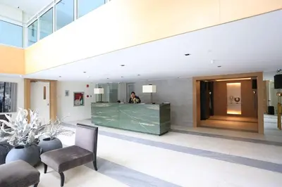 a man standing at a counter in a lobby at Maui Condotel Azure Residence in Manila