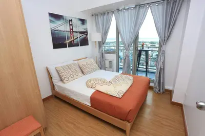 a bedroom with a bed with a heart pillow at Maui Condotel Azure Residence in Manila