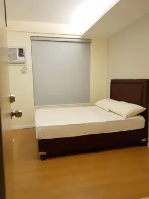 a bed in a room with a large window at The Leaf House in Manila