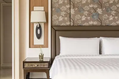 a bedroom with a bed and a table with a lamp at Edsa Shangri-La, Manila in Manila