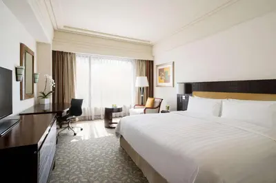 a hotel room with a large bed and a desk at Edsa Shangri-La, Manila in Manila
