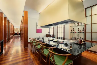 a kitchen with a long bar with chairs at Edsa Shangri-La, Manila in Manila