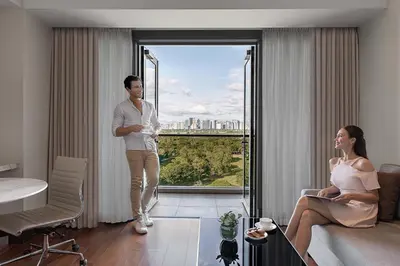 a man and a woman standing in a living room at Manila Marriott Hotel at Newport World Resorts in Manila