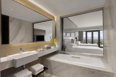 a bathroom with a tub and a sink and a bed at Manila Marriott Hotel at Newport World Resorts in Manila