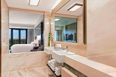 a bathroom with two sinks and a large mirror at Manila Marriott Hotel at Newport World Resorts in Manila