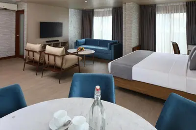 a hotel room with a bed and a table and chairs at City Garden Suites Manila in Manila