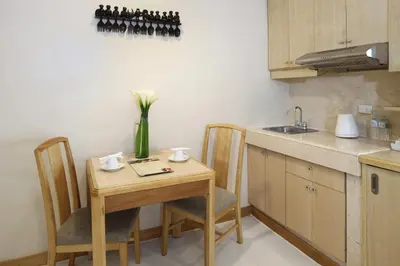a kitchen with a small table with a vase of flowers on it at Manila Lotus Hotel in Manila
