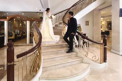 a bride and groom walking down the stairs at Manila Lotus Hotel in Manila