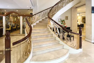a spiral staircase in a lobby with a restaurant at Manila Lotus Hotel in Manila