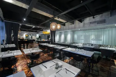a restaurant with tables and chairs in a room at The Picasso Boutique Serviced Residences Managed by HII in Manila