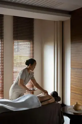 a woman getting a mans massage in a hotel room at Dusit Thani Manila in Manila