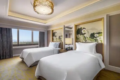 a hotel room with two beds and a window at Dusit Thani Manila in Manila
