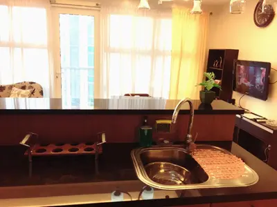 a kitchen with a sink and a counter with windows at Luckycat Homestay in Manila