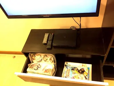a black table with a television and a laptop on it at Luckycat Homestay in Manila
