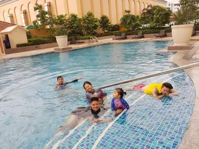 a group of people swimming in a swimming pool at Luckycat Homestay in Manila