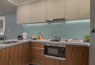a kitchen with stainless steel appliances and wooden cabinets at Ascott Makati in Manila