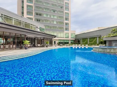 a large blue swimming pool in front of a building at Ascott Makati in Manila