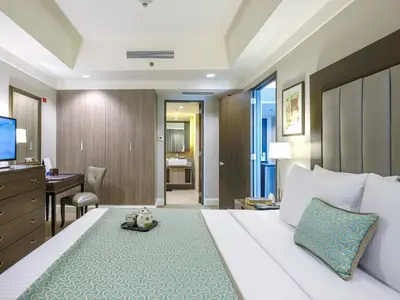 a hotel room with a large bed and a desk at Somerset Millennium Makati in Manila