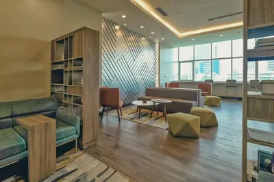 a lobby with a couch and a table and chairs at Somerset Millennium Makati in Manila