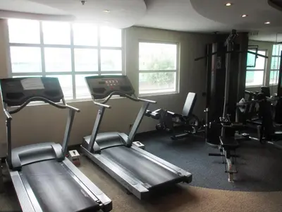a gym with two tread machines in a room at Crown Regency Hotel Makati in Manila