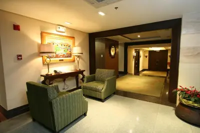 a hotel lobby with two chairs and a desk at Crown Regency Hotel Makati in Manila