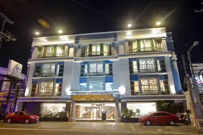 a building with two cars parked in front of it at Crown Regency Hotel Makati in Manila